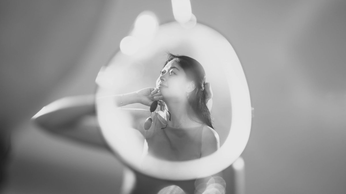 Femme réfléchissante dans un miroir circulaire.