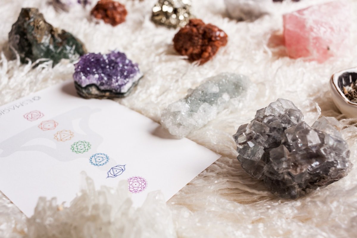 Cristaux de quartz, améthyste, et autres minéraux colorés sur papier avec symboles.