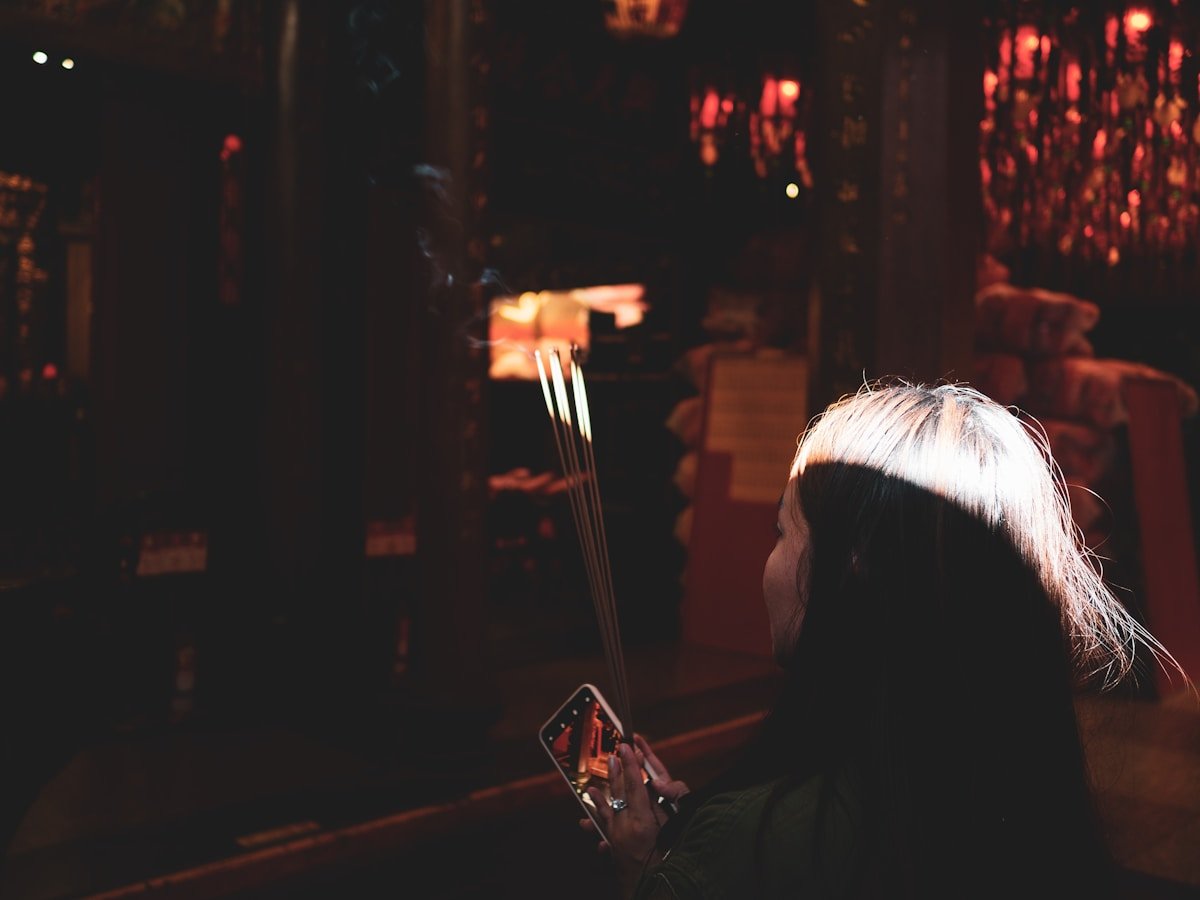 Personne tenant un smartphone dans un endroit sombre et éclairé.