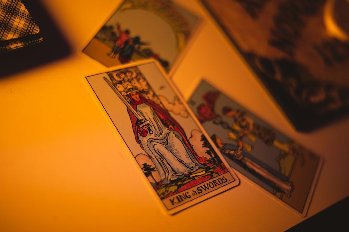 Cartes de tarot vintage avec le roi d'épées sur fond orange.