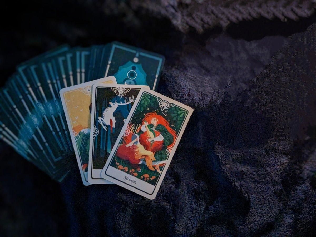 Cartes de tarot colorées avec une illustration fantastique sur fond sombre.