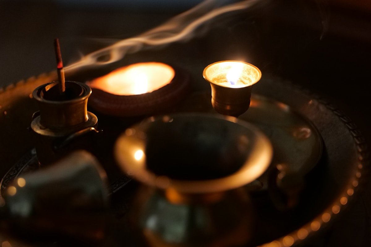 Bougies allumées, vapeur, objets en métal, éclairage tamisé, atmosphère méditative.