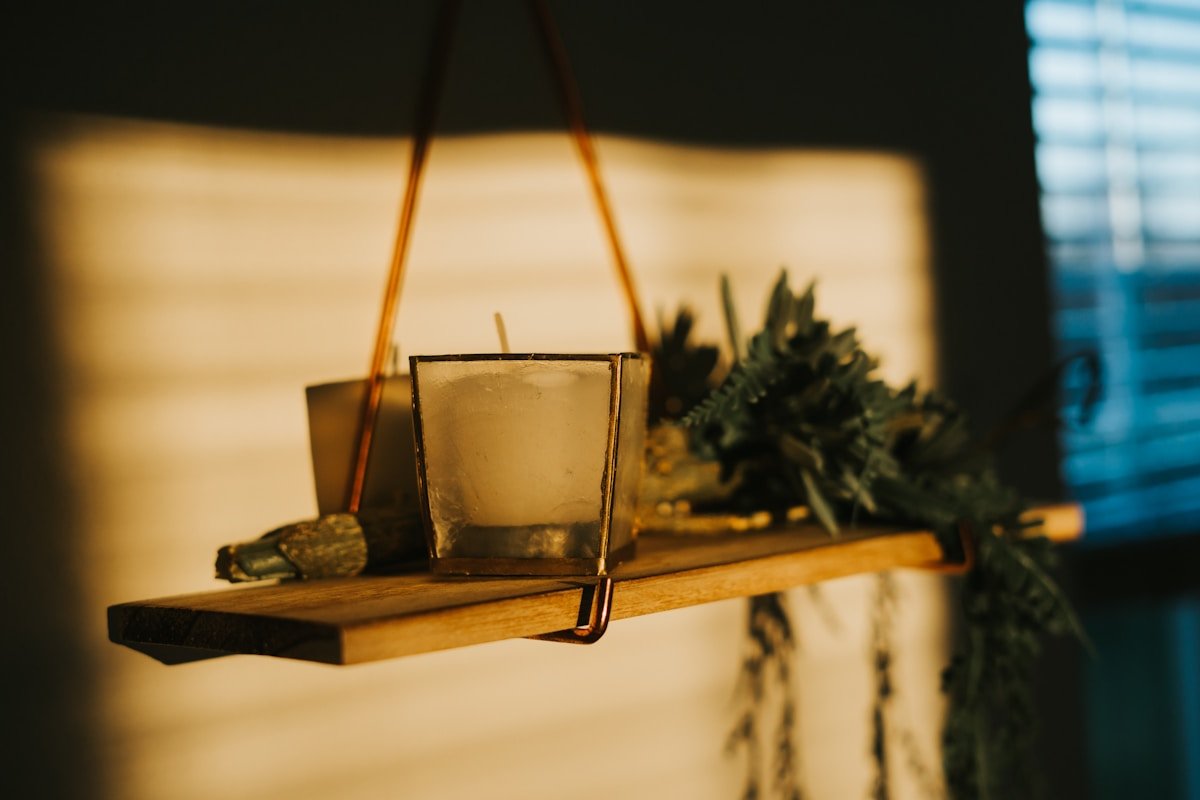 Verre de boisson sur une étagère en bois avec des plantes.