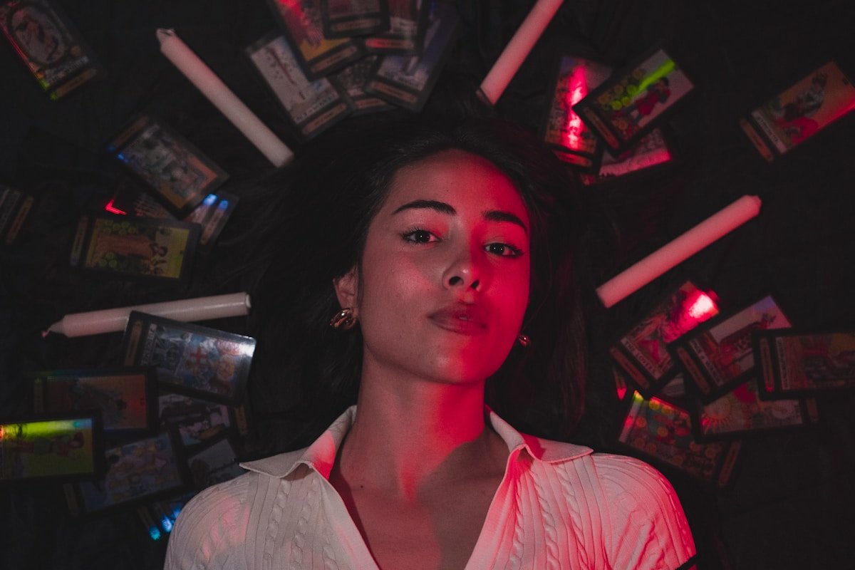 Jeune femme pensive dans un environnement sombre et coloré.