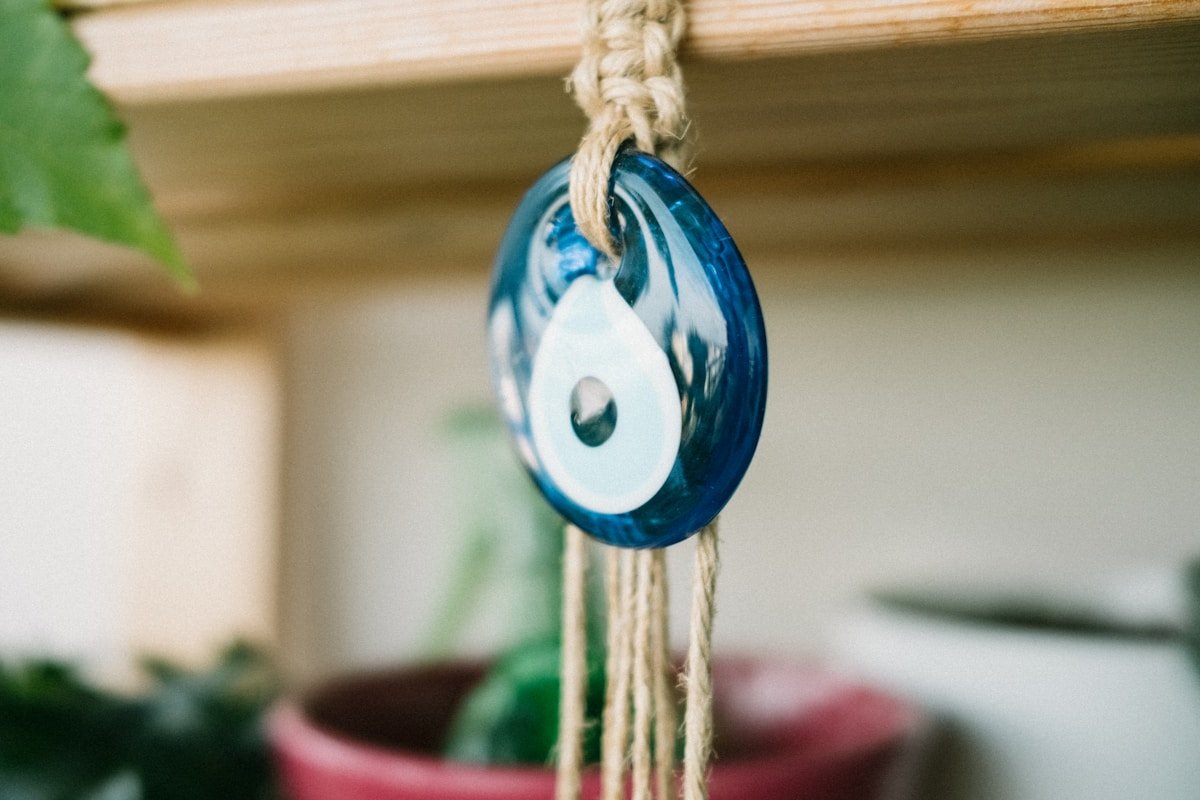 Amulette bleue en verre suspendue par une corde.