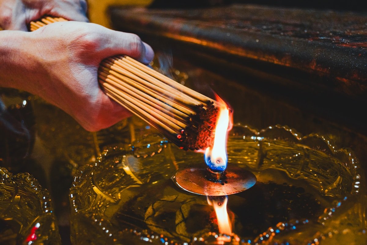 Bâtonnets de bois allumés dans un liquide enflammé.