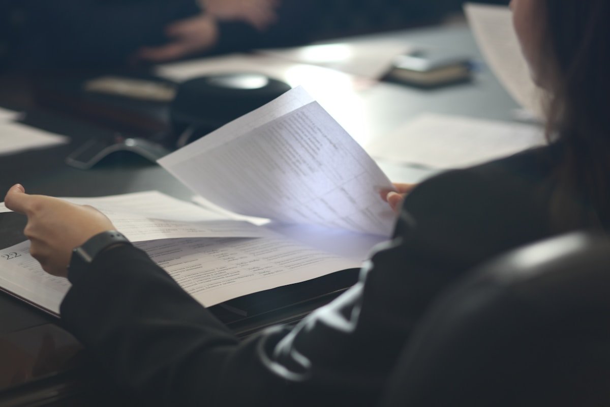 Documents et formulaires sur un bureau sombre.