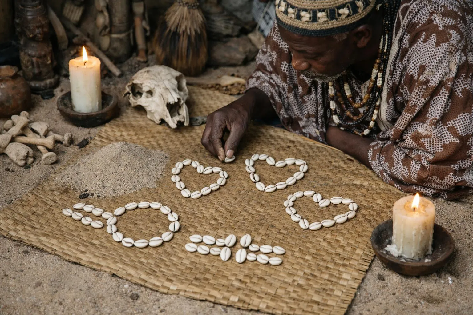 Rituel spirituel avec crâne, bougies et coquillages formant des symboles.