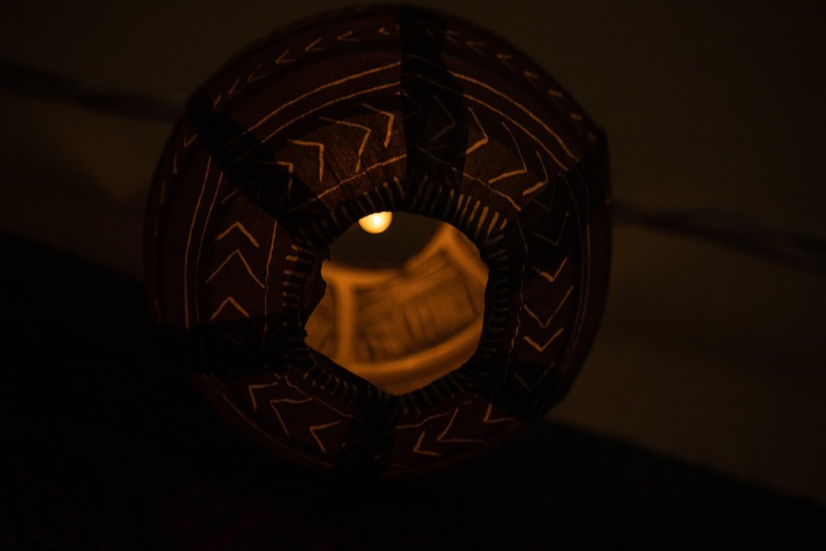 Lampe décorative sphérique avec motifs géométriques éclairée.
